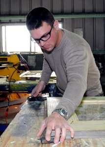 US Navy 100224-N-6357K-005 Builder 3rd Class Greg Lever, from Londonderry, N.H., assigned to Naval Mobile Construction Battalion (NMCB) 7, assembles a picture frame to be used in the refurbished Camp Mitchell chaplain's office