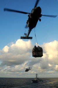US Navy 100225-N-3038W-301 Two MH-60S Sea Hawk helicopters conduct a vertical replenishment between USS Sampson (DDG 102) and USNS Bridge (T-AOE 10)