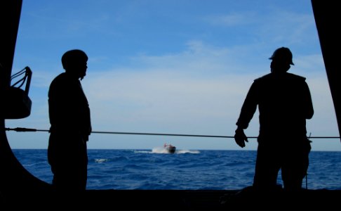 US Navy 100224-N-7058E-041 Mineman 1st Class Jeffrey Steele, left, and Chief Boatswain's Mate Trevor Davis watch from the starboard-side door of the littoral combat ship USS Freedom (LCS 1) as it prepares for a small-boat tran