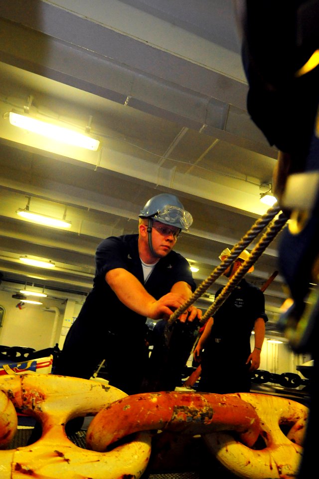 US Navy 100226-N-2953W-378 Boatswain's Mate 2nd Class Brandon Terry reapplies a pelican hook to the anchor chain in the forecastle of the aircraft carrier USS Carl Vinson (CVN 70)