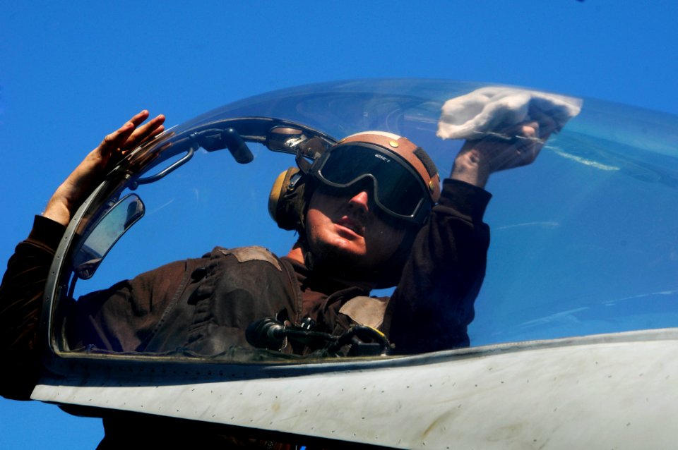 US Navy 100225-N-3038W-705 Aviation Structural Mechanic Airman James Gossard, assigned to the Sidewinders of Strike Fighter Squadron (VFA) 86, wipes down the canopy of an F-A-18C Hornet aboard the aircraft carrier USS Nimitz (C