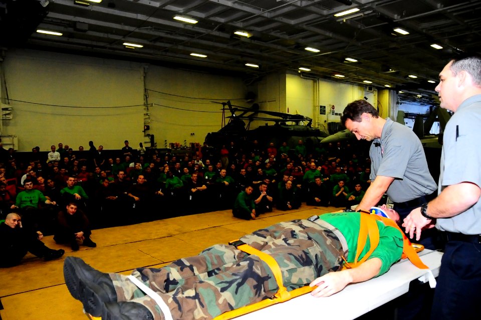 US Navy 100224-N-7939W-020 Paramedics Scott Neusch and Vincient Easevoli demonstrate on Electrician's Mate 3rd Class Joseph Childree aboard the aircraft carrier USS Nimitz (CVN 68) how paramedics treat accident victims