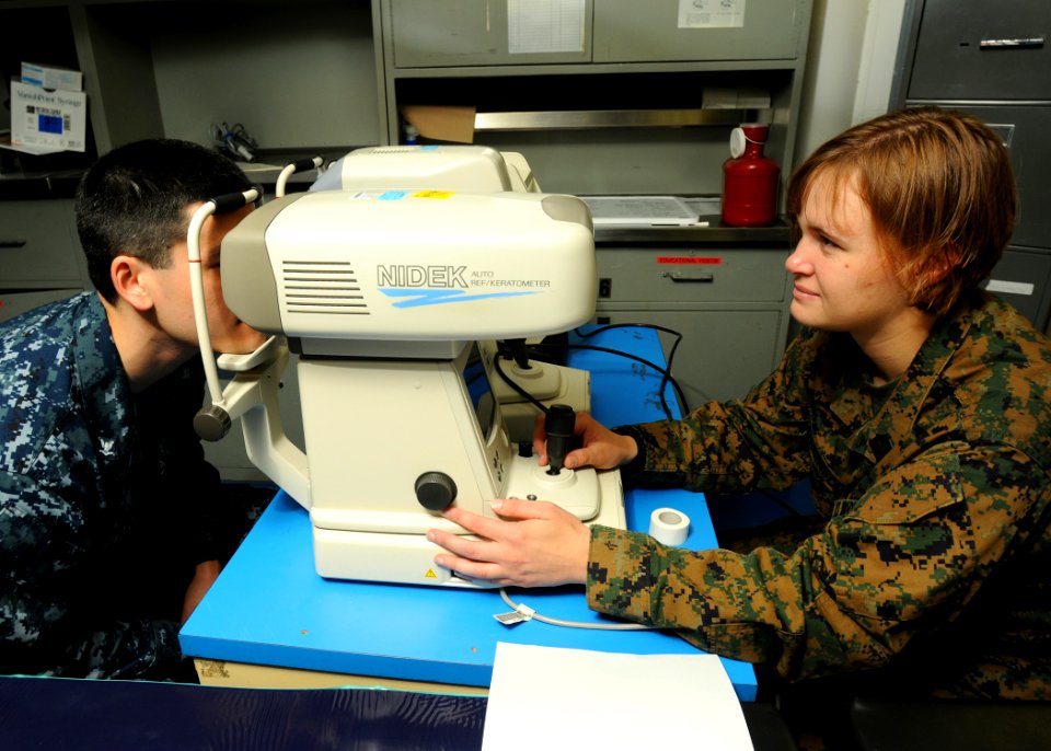 US Navy 100226-N-7948R-059 Hospital Corpsman 2nd Class Megan Anderson performs an eye exam on Electricians Mate 3rd Class Rarick James aboard the amphibious assault ship USS Peleliu (LHA 5) photo