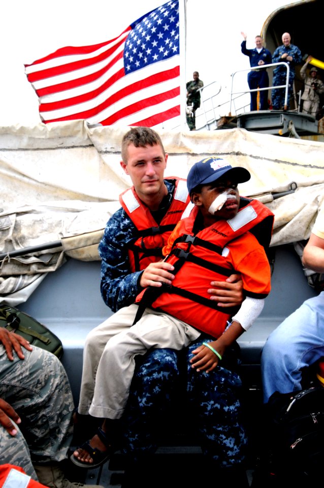 US Navy 100227-N-4995K-249 Hospital Corpsman 2nd Class James Gerity escorts a Haitian boy to Terminal Varreux in Port-au-Prince, Haiti
