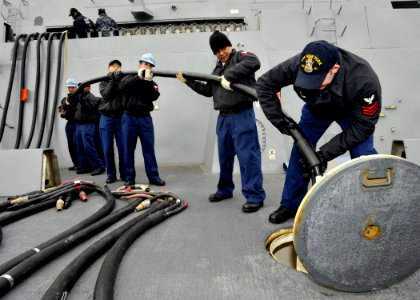 US Navy 100302-N-2147L-003 Sailors remove a shore power cable aboard SS New York (LPD 21) photo