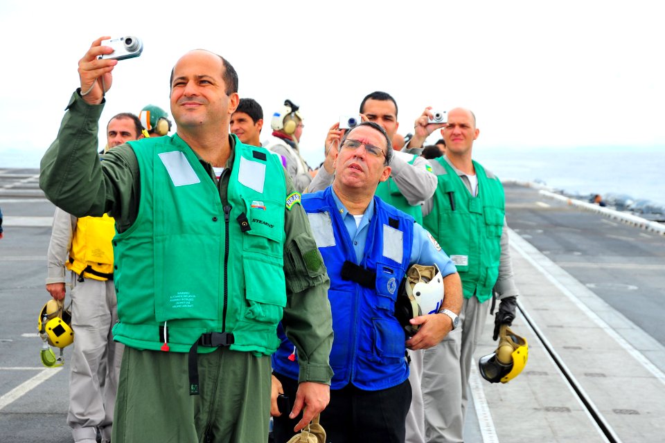 US Navy 100302-N-2953W-946 Brazilian visitors and service members photograph an F-A-18 Super Hornet during a flight demonstration on the flight deck of the nuclear-powered aircraft carrier USS Carl Vinson (CVN 70)