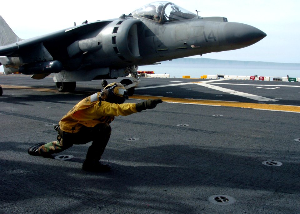 US Navy 100226-N-1226D-063 Aviation Boatswain's Mate (Handling) Joeffrey Mamaril gives the launch signal to Marine Capt. Eric Fong, piloting an AV-8B Harrier