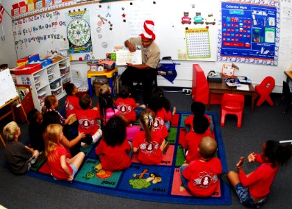 US Navy 100227-N-0995C-010 A Sailor reads to a class of kindergarten students at Iroquois Point Elementary School photo