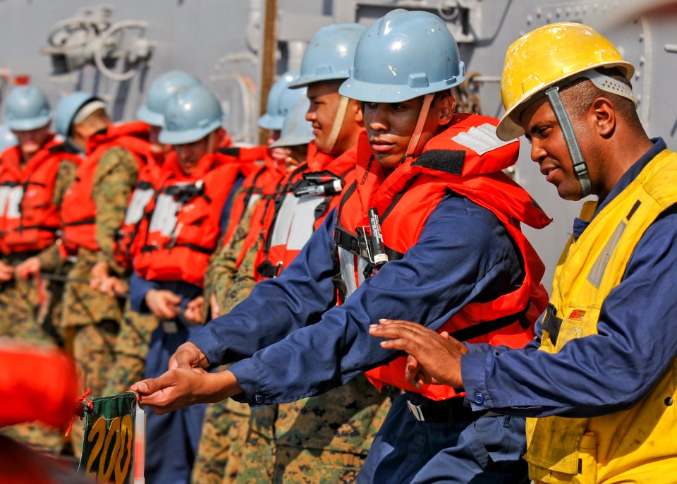 US Navy 100302-N-9950J-419 Boatswain's Mate 2nd Class Charlie Matthews supervises as Seaman Anthony Bowser steadies the phone and distance line aboard the forward-deployed amphibious assault ship USS Essex (LHD 2)