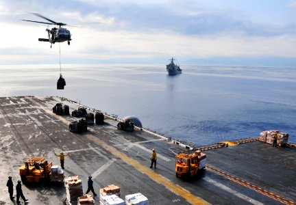 US Navy 100228-N-9740S-018 An MH-60S Sea Hawk helicopter from Helicopter Sea Combat Squadron (HSC) 22 delivers pallets of supplies to the multi-purpose amphibious assault ship USS Bataan (LHD 5) photo
