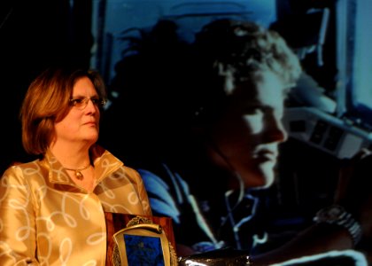 US Navy 100227-N-5812W-001 Astronaut and U.S. Navy Reserve Capt. Kathy Sullivan stands during her induction into the Women in Aviation International Pioneer Hall of Fame as photos from her accomplishments flash on a screen behi