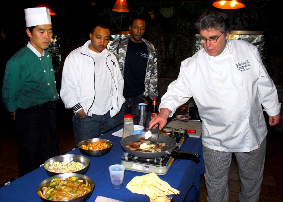US Navy 100228-N-9573A-008 Chef Trevor Hamilton prepares grilled flank steaks at the Navy Club for single Sailors stationed in Seoul, Republic of Korea