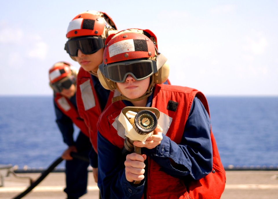 US Navy 100301-N-6692A-011 Damage Controlman Fireman Alicia Asbell leads hose team members in crash and smash fire training drills