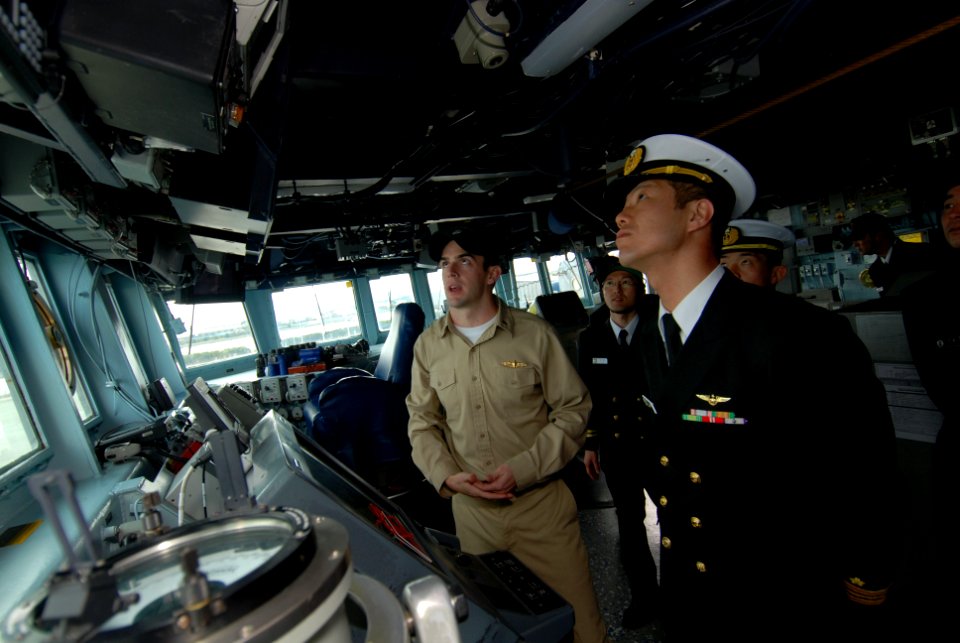 US Navy 100302-N-3283P-061 Lt. j.g. Jack Kelley, assistant navigator aboard the guided-missile destroyer USS Pinckney (DDG 91), explains the capabilities of the ship's bridge to members of the Japan Maritime Self-Defense Force