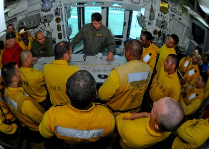 US Navy 100301-N-9950J-090 Lt. Matthew Baker briefs Sailors assigned to the forward-deployed amphibious assault ship USS Essex (LHD 2) before flight quarters