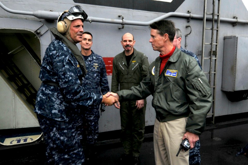 US Navy 100302-N-3038W-133 Rear Adm. Robert P. Girrier, left, is greeted by Capt. Paul Monger, commanding officer of the aircraft carrier USS Nimitz (CVN 68)