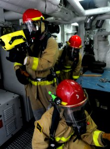 US Navy 100303-N-7280V-509 Sailors use a Naval Firefighting Thermal Imager (NFTI) to asses a simulated casualty during a main space fire drill photo