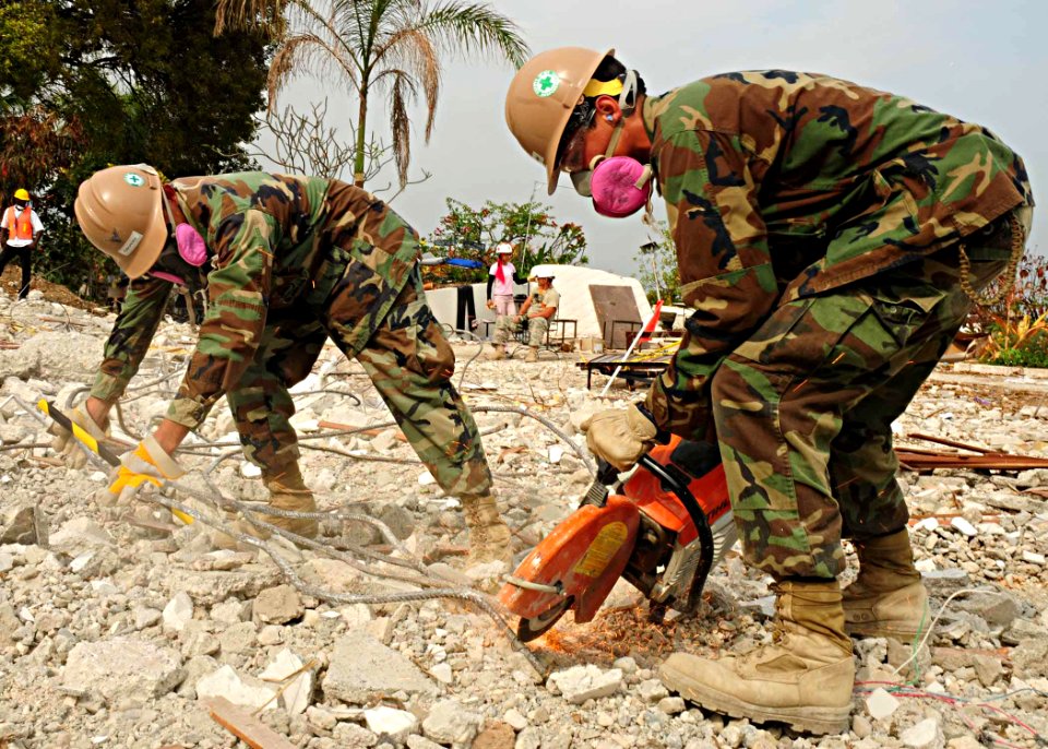 US Navy 100303-N-9643W-011 Sailors assigned to the air detachment of Naval Mobile Construction Battalion (NMCB) 7 cut rebar during a search and recovery mission at the Hotel Montana in Port-au-Prince, Haiti