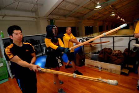 US Navy 100301-N-3283P-217 Lt. jg Yashuro Tomizuka, a member of the Japan Maritime Self-Defense Force, demonstrates how to properly hold a kendo sword to Sailors assigned to the guided-missile destroyer USS Pinckney (DDG 91)
