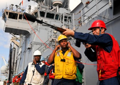 US Navy 100302-N-9950J-138 Gunner's Mate 3rd Class Edward Oyola prepares to fire the phone and distance line from the forward-deployed amphibious assault ship USS Essex (LHD 2)