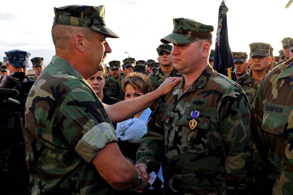 US Navy 100304-N-1786N-033 Rear Adm. Albert Garcia III thanks Hospital Corpsman 1st Class Robert Riley after awarding him the Purple Heart medal