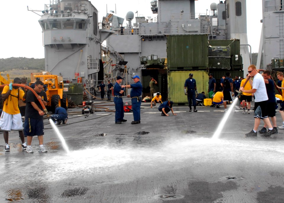 US Navy 100302-N-2000D-065 Sailors aboard the amphibious dock landing ship USS Carter Hall (LSD 50) use fire hoses to spray water on the flight deck