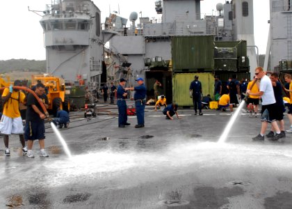US Navy 100302-N-2000D-065 Sailors aboard the amphibious dock landing ship USS Carter Hall (LSD 50) use fire hoses to spray water on the flight deck photo