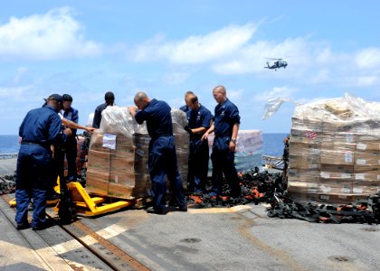 US Navy 100304-N-7088A-061 Sailors aboard the Arleigh Burke-class guided-missile destroyer USS Farragut (DDG 99) unload pallets of supplies during a vertical replenishment at sea