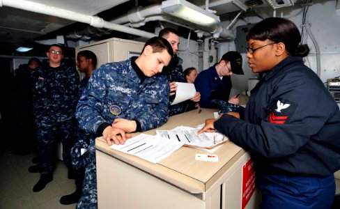 US Navy 100303-N-6003P-008 Personnel Specialist 2nd Class Audrea Hardy, from Pittsburgh, Pa, assists Sailors update their Page 2 sheets prior to their upcoming deployment