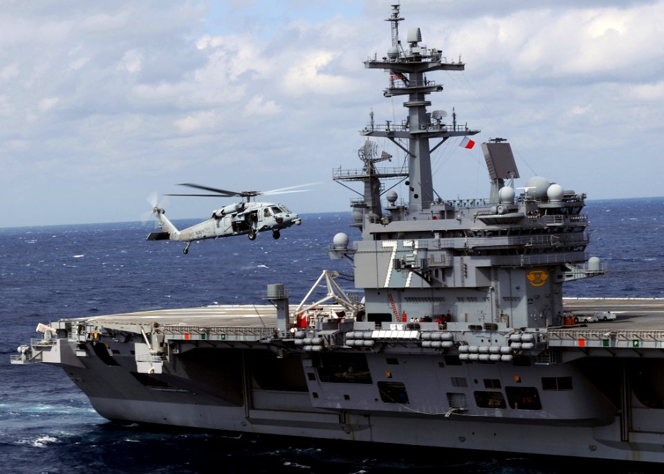 US Navy 100303-N-3885H-172 An MH-60S Sea Hawk helicopter flies alongside USS George H.W. Bush (CVN 77)