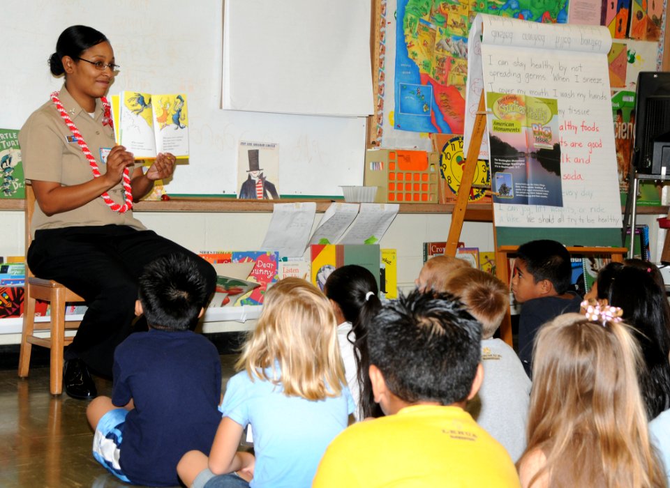 US Navy 100303-N-3666S-012 Boatswains Mate 2nd Class Rasheema Newsome, assigned to Commander, Navy Region Hawaii, reads a Dr. Seuss book to students at Lehua Elementary School