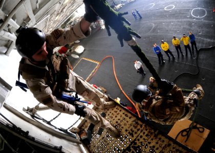 US Navy 100303-N-4236E-204 An explosive ordnance disposal member participates in a fast-rope training exercise in the hangar bay of the Nimitz-class aircraft carrier USS Dwight D. Eisenhower (CVN 69)
