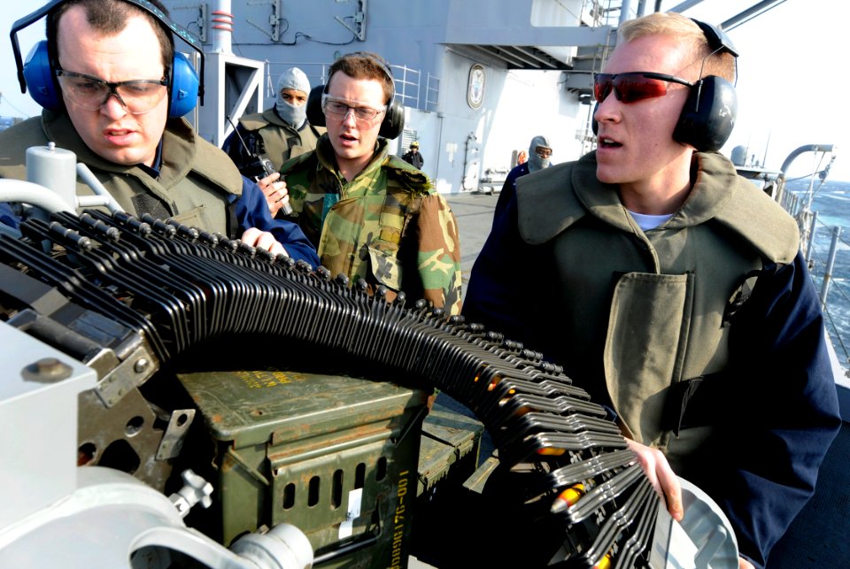 US Navy 100303-N-7280V-505 Gunner's Mates 3rd Class Brandon Field and William Bush load a Mk-38 25 mm machine gun system during a crew served weapons qualification shoot aboard the U.S. 7th Fleet command ship USS Blue Ridge (LC