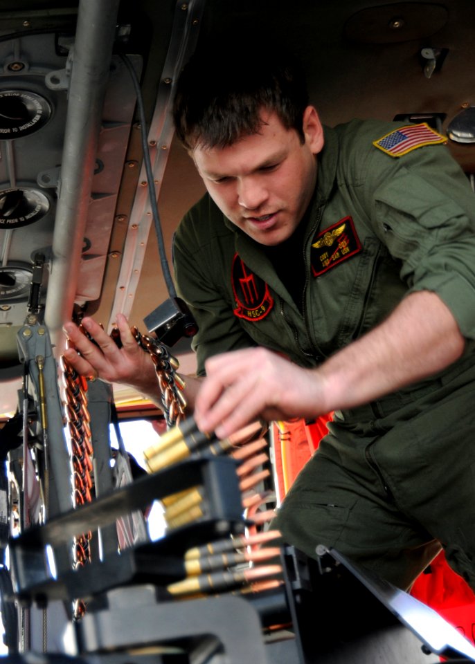 US Navy 100304-N-9116S-153 Naval Air Crewmen 2nd Class Cody J. Cox loads a 600-round ammo can in an MH-60S Sea Hawk helicopter
