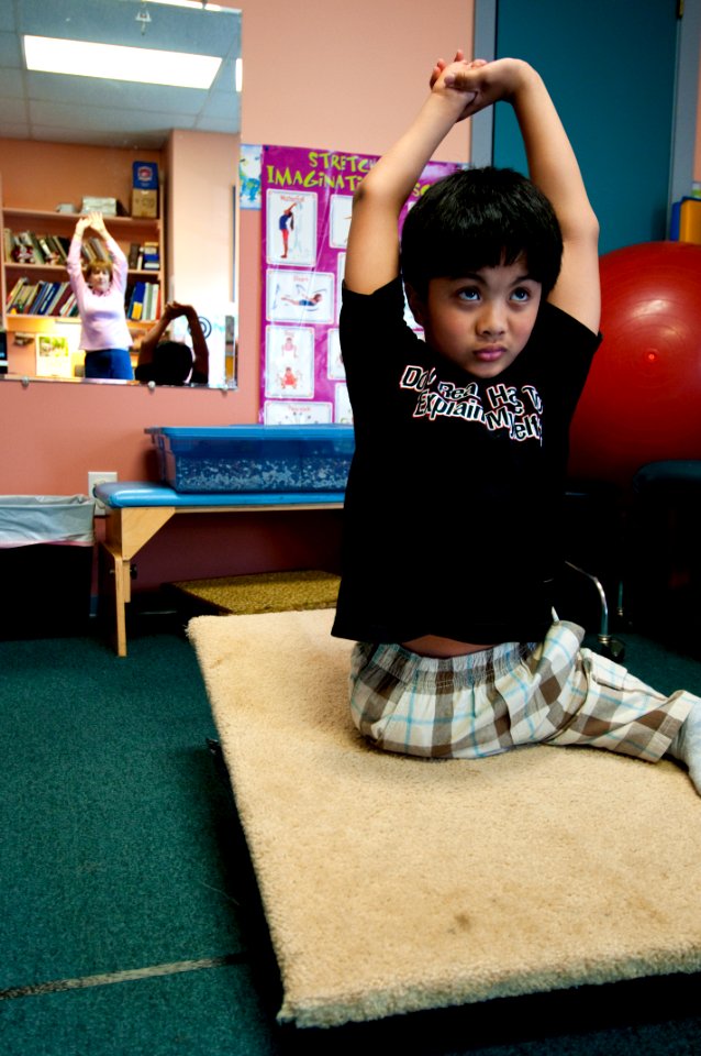 US Navy 100306-N-5319A-035 Ten-year-old Joseph Camano performs stretching exercises before a routine physical therapy session with Occupational Therapist Judy Anderson at the Diane Epplein ^ Assoc. Pediatric Therapy facility