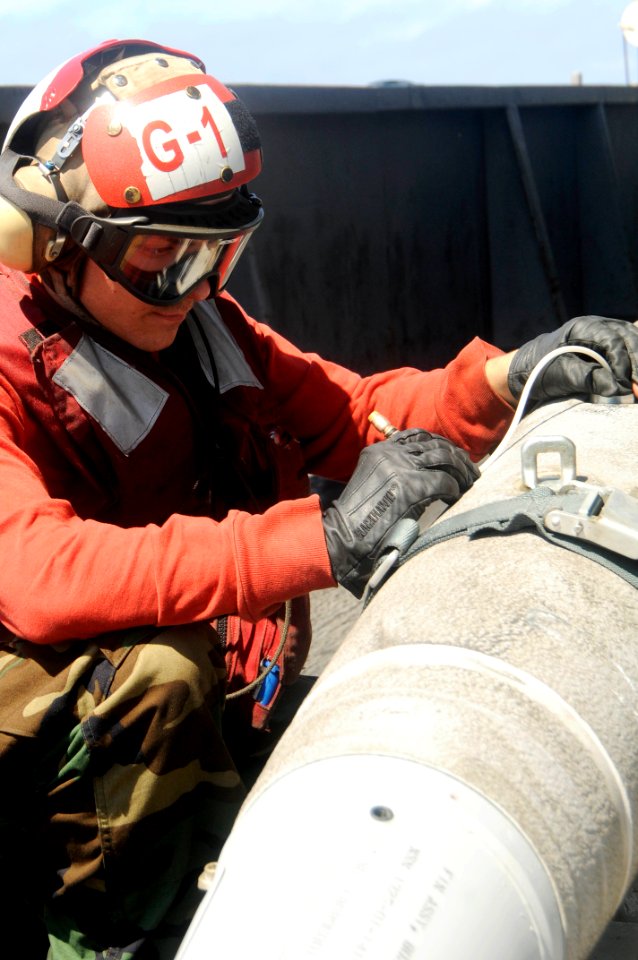 US Navy 100305-N-3038W-187 Aviation Ordnanceman Airman Alex Costin, from Elyria, Ohio, inspects an arming switch on an MK 82-BLU 111 2500-pound bomb aboard the aircraft carrier USS Nimitz (CVN 68)
