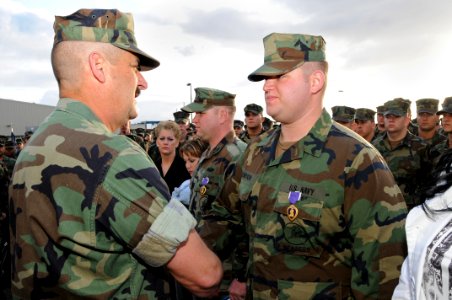 US Navy 100304-N-1786N-037 Rear Adm. Albert Garcia III thanks Steelworker Constuctionman Aaron Thompson after awarding him the Purple Heart medal