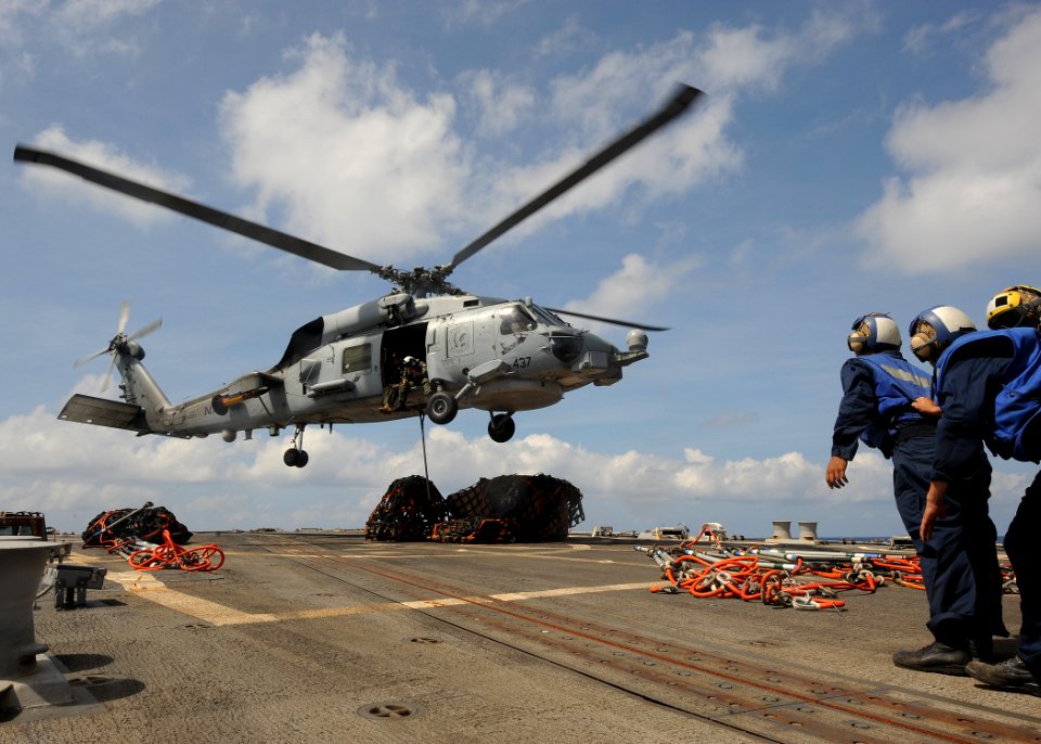 US Navy 100304-N-7088A-131 An SH-60B helicopter prepares to transfer supplies to the Military Sealift Command fleet replenishment oiler USNS Patuxent (T-AO 201)