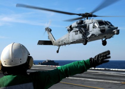 US Navy 100308-N-7908T-149 A Sailor assigned to Helicopter Sea Combat Squadron (HSC) 9 signals to an MH-60S Sea Hawk helicopter as it takes off from the aircraft carrier USS George H.W. Bush (CVN 77)