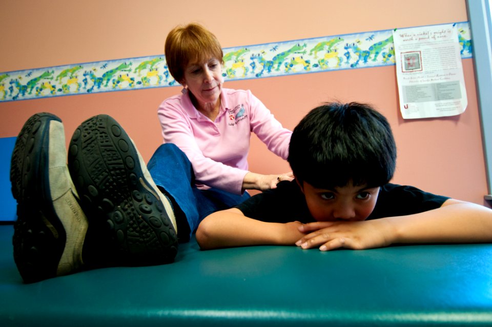 US Navy 100306-N-5319A-020 Occupational Therapist Judy Anderson exercises muscles in ten-year-old Joseph Camano's lower back during a routine physical therapy session at the Diane Epplein ^ Assoc. Pediatric Therapy facility