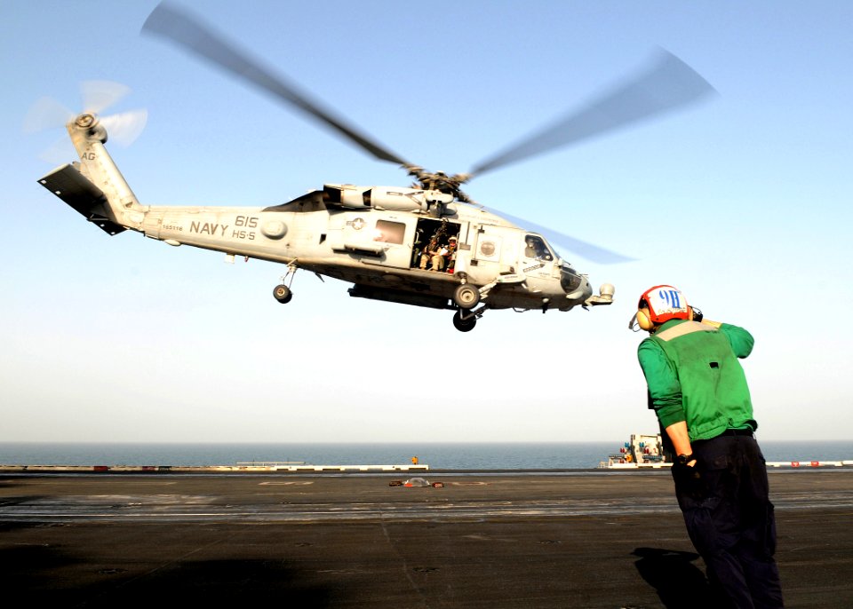 US Navy 100309-N-4236E-429 A Sailor salutes as an HH-60H Sea Hawk helicopter takes off from USS Dwight D. Eisenhower (CVN 69)
