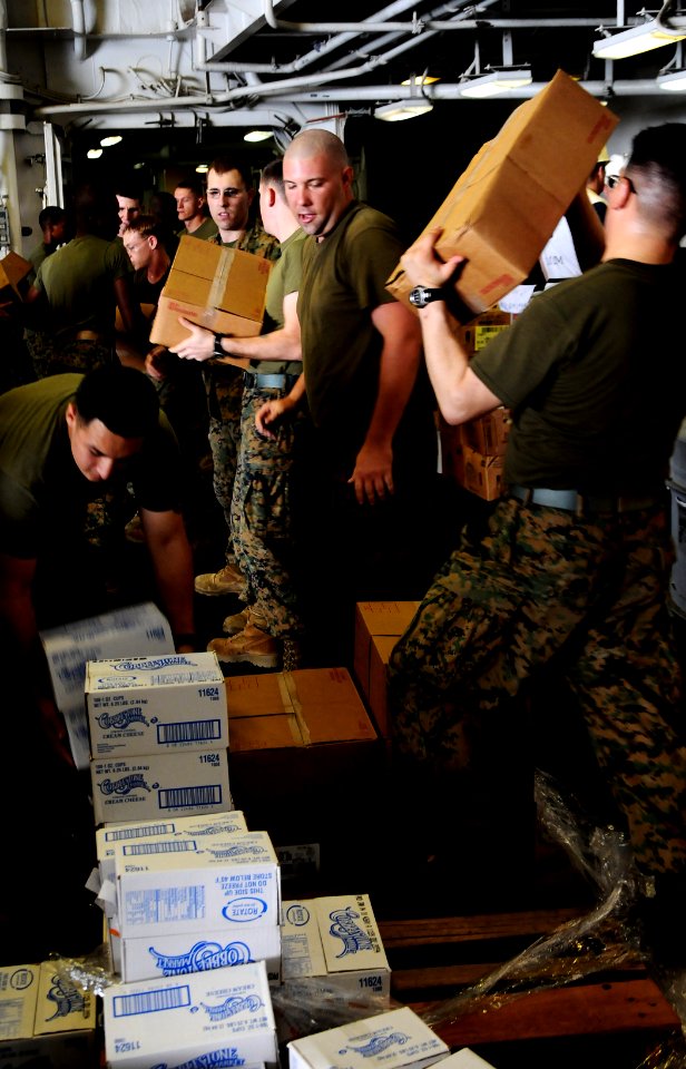 US Navy 100309-N-8655E-009 Marines assigned to the 22nd Marine Expeditionary Unit (22nd MEU) unload pallets of food and supplies aboard the multipurpose amphibious assault ship USS Bataan (LHD 5)