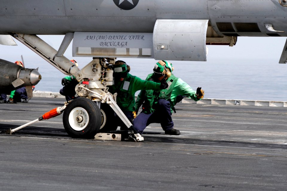 US Navy 100307-N-6604E-099 Sailors inspect an aircraft and a catapult shuttle before launching an F-A-18C Hornet from the Wildcats of Strike Fighter Squadron (VFA) 131 during flight operations aboard the Nimitz-class aircraft c