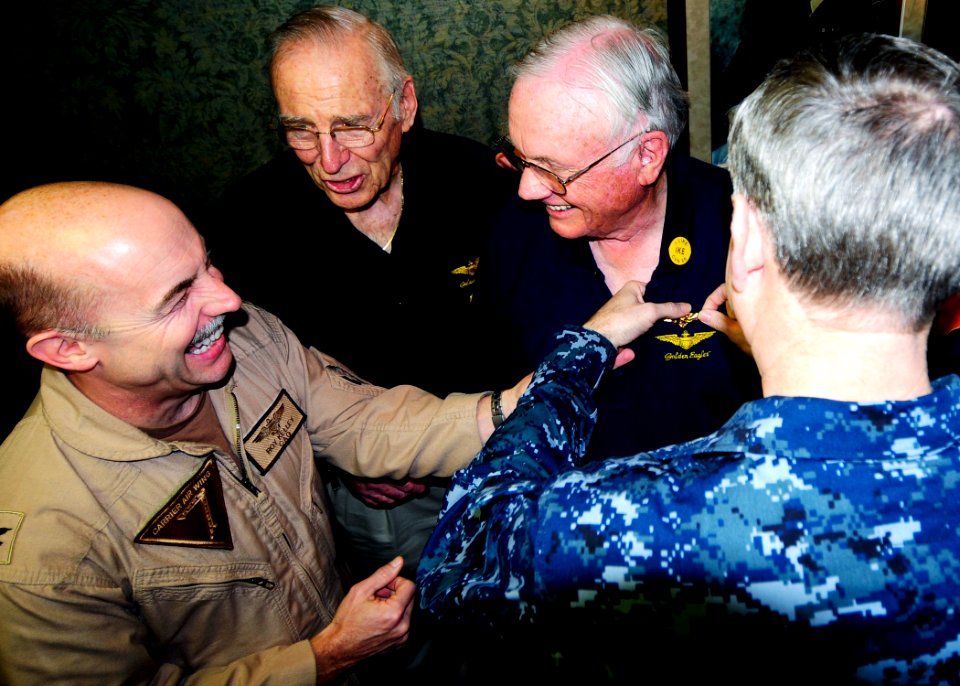US Navy 100310-N-6854D-003 Capt. Roy J. Kelley, commander of Carrier Air Wing (CVW) 7, and Capt. Dee L. Mewbourne, commanding officer of the aircraft carrier USS Dwight D. Eisenhower (CVN 69) present Neil Armstrong, the first m