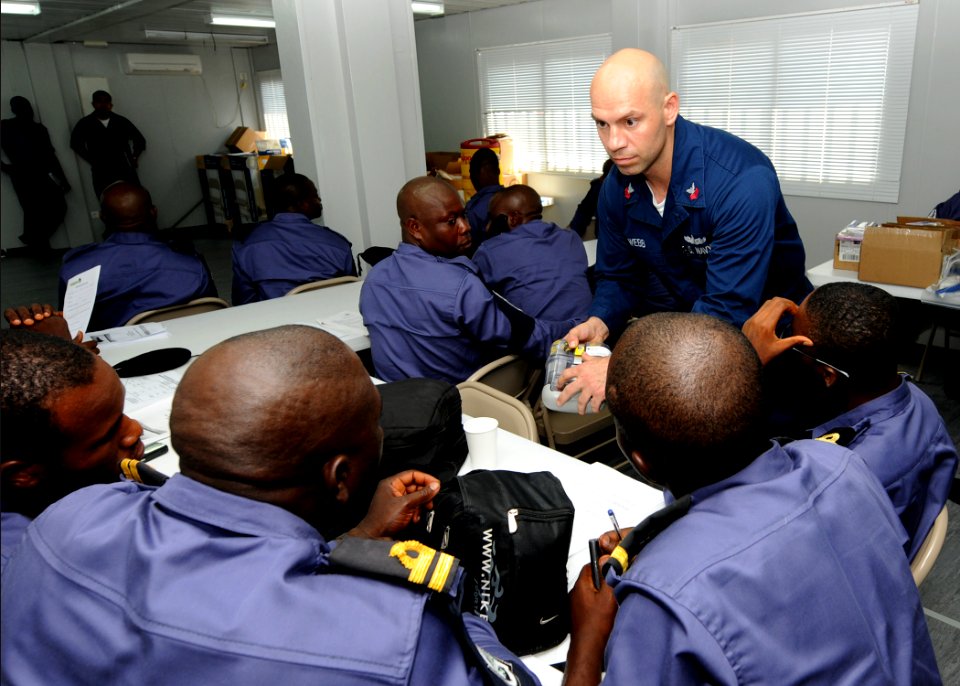 US Navy 100308-N-6676S-108 Sailors from the Nigerian navy listen as Damage Controlman 1st Class Cory Webb, from Smithfield, Va., demonstrates how to properly use an emergency escape breathing device (EEBD) during a training ses