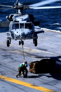 US Navy 100311-N-4275C-420 An SH-60 Sea Hawk helicopter picks up supplies aboard USS Carl Vinson (CVN 70)