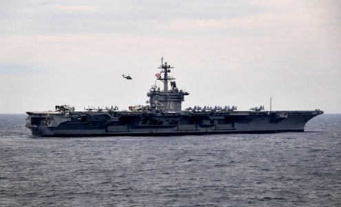 US Navy 100308-N-4774B-748 A helicopter flies over the Nimitz-class aircraft carrier USS Carl Vinson (CVN 70) during Southern Seas 2010