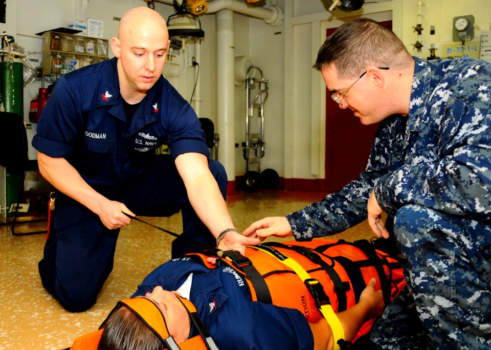 US Navy 100309-N-1092P-054 Hospital Corpsman 2nd Class Casey Goodman and Logistics Specialist 2nd Class Christopher Vytlacil demonstrate how to properly secure an injured person