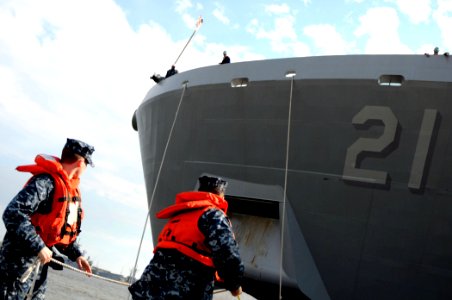 US Navy 100310-N-8590G-012 Quartermaster 3rd Class Mark Dollof and Operations Specialist Seaman Kyle Willis heave a mooring line from USS New York (LPD 21)