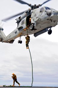 US Navy 100309-N-6006S-676 Explosive ordnance disposal technicians perform tactical fast rope maneuvers on the flight deck of the aircraft carrier USS Carl Vinson (CVN 70) during an air show for Argentinean visitors